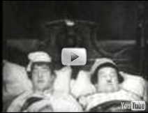 Laurel and Hardy opening scene of movie in bed together. 
